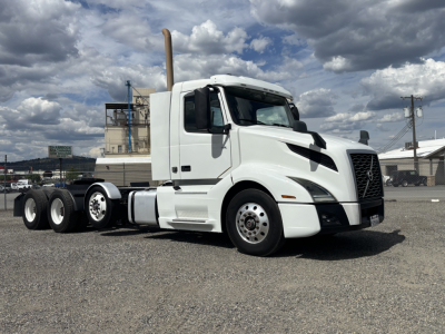 2019 Volvo VNL84T300 conventional daycab tractor shown in white, three-axle rear, side view with exhaust stack and Volvo grille, no visible damage.