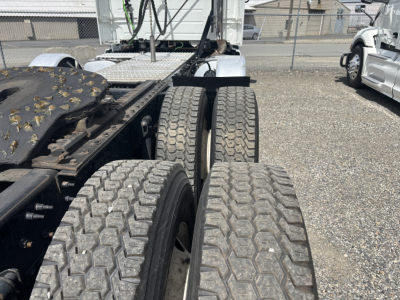 Truck chassis and dual rear axles of a 2019 Volvo VNL84T300 showing the rear wheel area and fifth wheel plate.