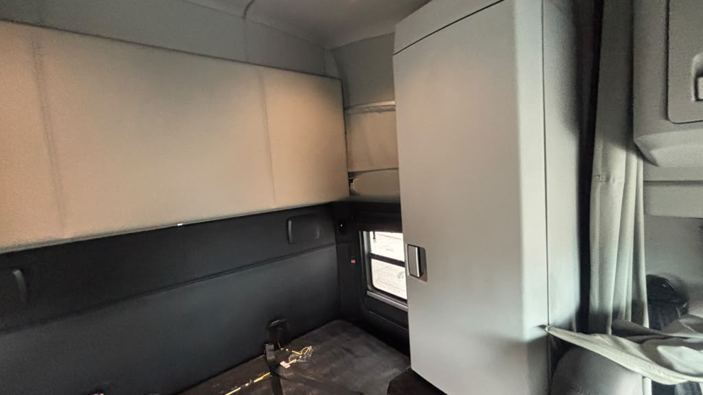 Kenworth T680 sleeper cab interior corner view showing storage cabinet and window