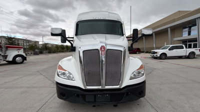 Kenworth T680 truck front view showing grille, headlights, and emblem, white cab, chrome mirrors.