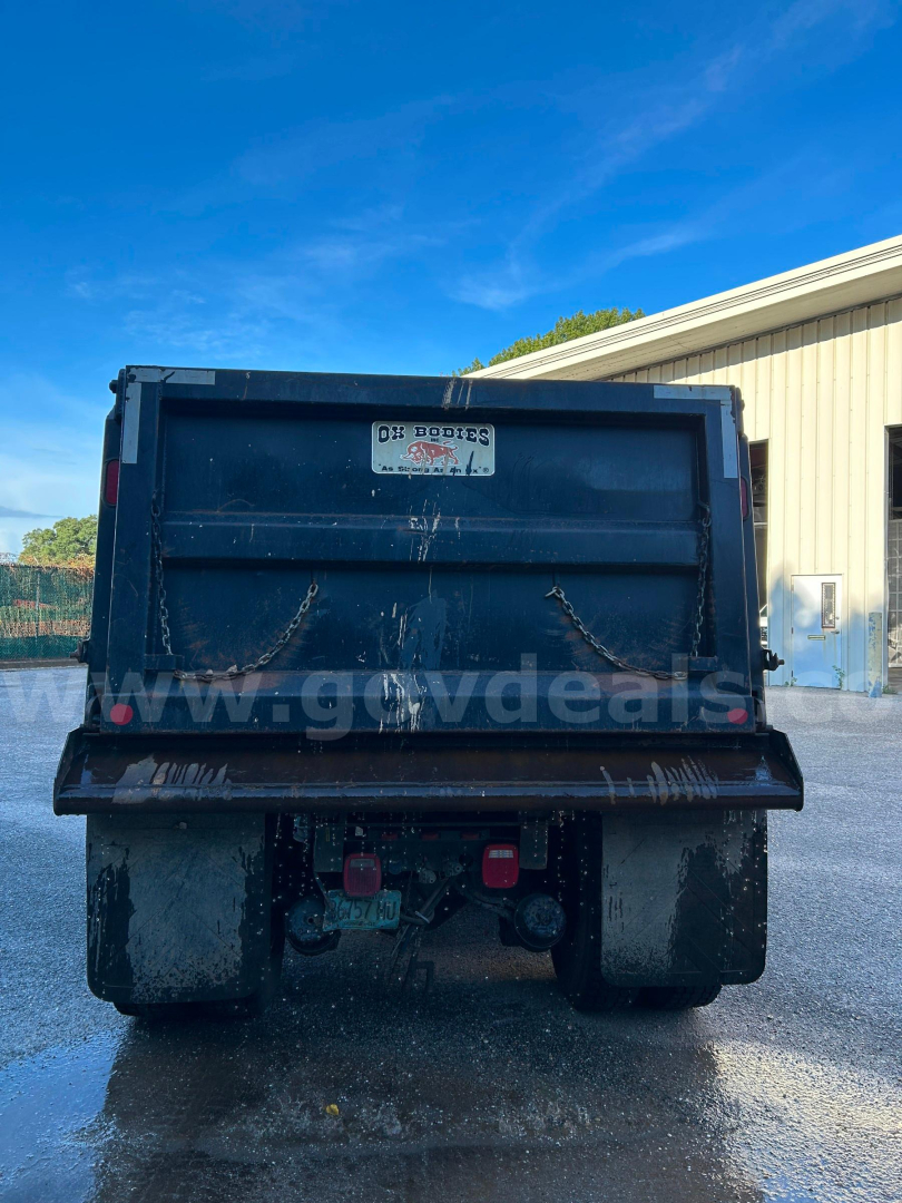 Dump truck bed of a 2017 Kenworth T370 rear view showing U-ditch dump body with tandem rear wheels and registration tag.