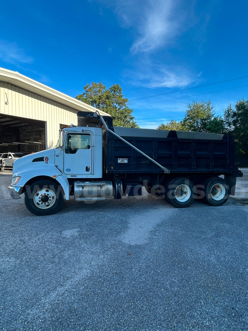 Kenworth T370 dump truck side view showing dump bed and hydraulic hoist with cab, chrome wheels, and blue exterior.