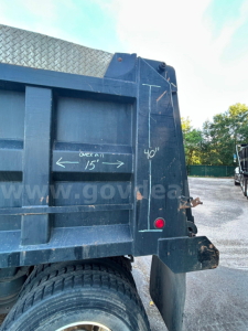 Kenworth T370 dump truck side rear showing tailgate and chalk markings: 40" height, 15" overflow, 60" wheel base area, rear light, blue paint.