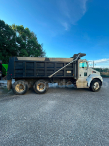 Kenworth T370 dump truck side view showing cargo bed and dual rear axles.