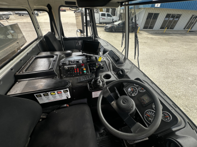 Dashboard and steering wheel of a 2019 Autocar garbage truck interior showing control console, gauges, gear shifter, and steering wheel.