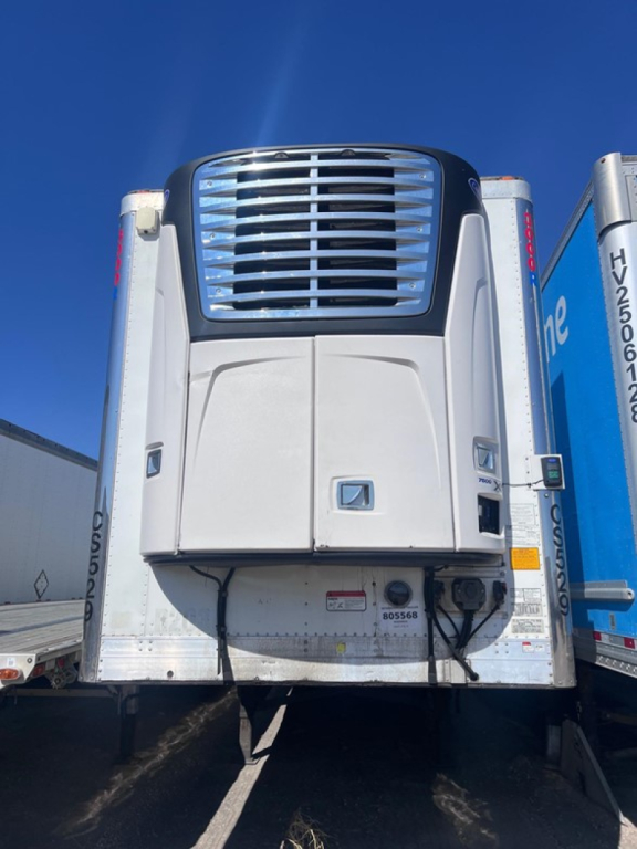 Utility reefer trailer front view showing Carrier cooling unit and lower access panel with VIN label.