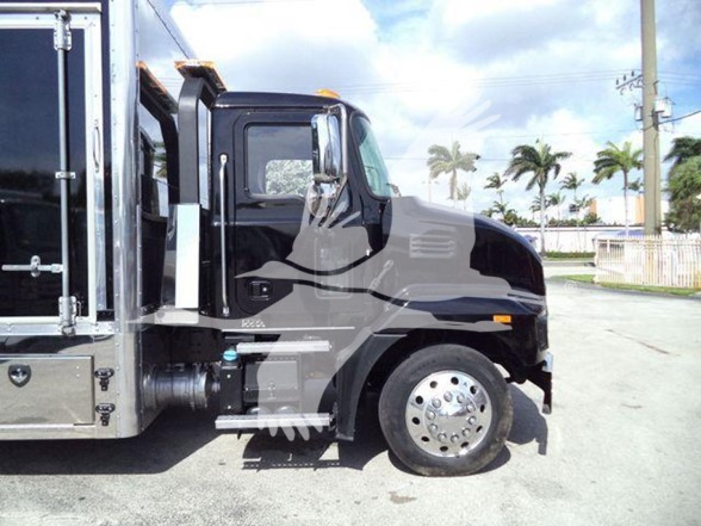 Truck cab and front wheel of a 2022 Mack MD6 rollback truck showing cab, wheel, and side area.