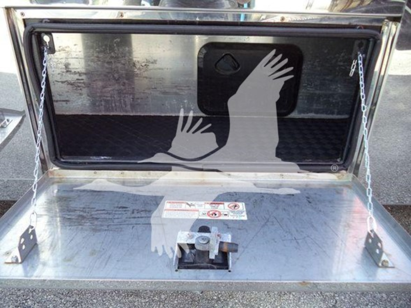 Trunk of 2022 Mack MD6 rollback showing rear storage area with metal deck, hinged tailgate, and warning labels.