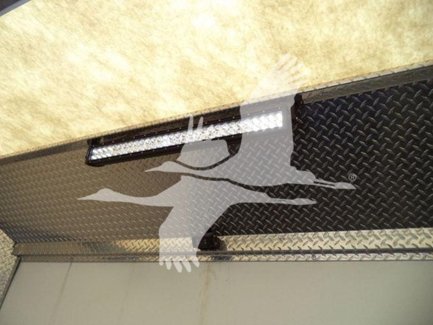 Mack MD6 truck bed or side panel with diamond plate texture and a slim LED light bar mounted above a metal surface.
