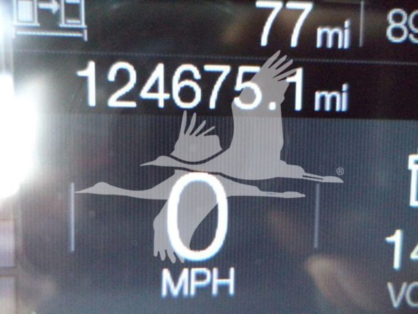 Mack MD6 truck dash showing odometer reading 124675.1 miles and 0 MPH, with partial trip data and gauges visible.