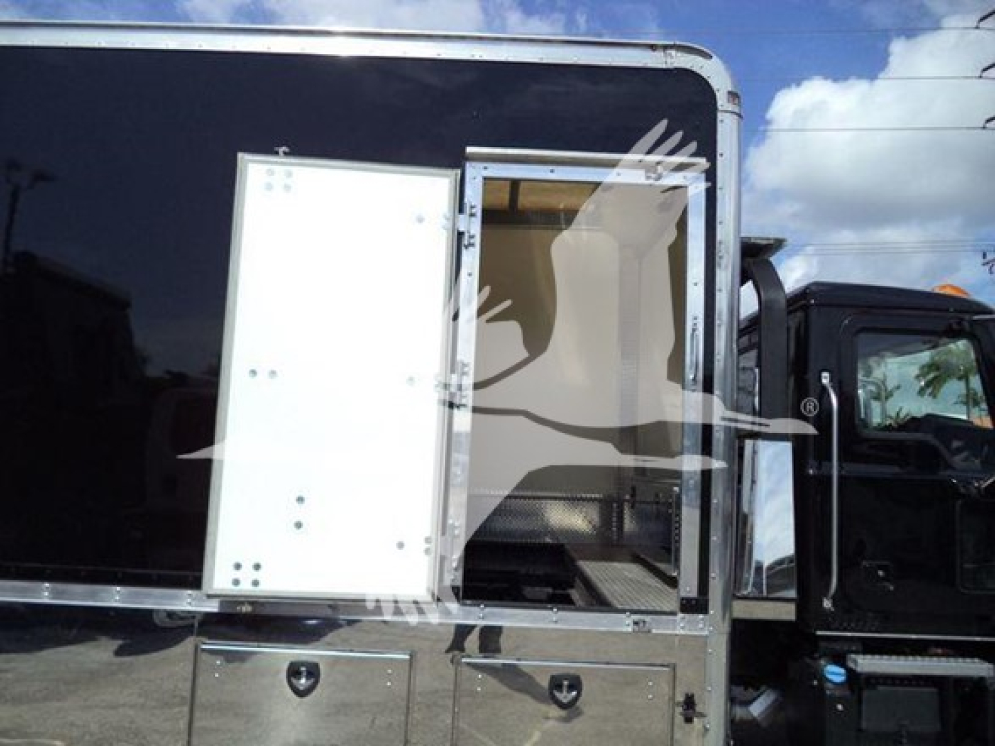 Mack MD6 rollback truck side view showing side entry door and metal storage compartments