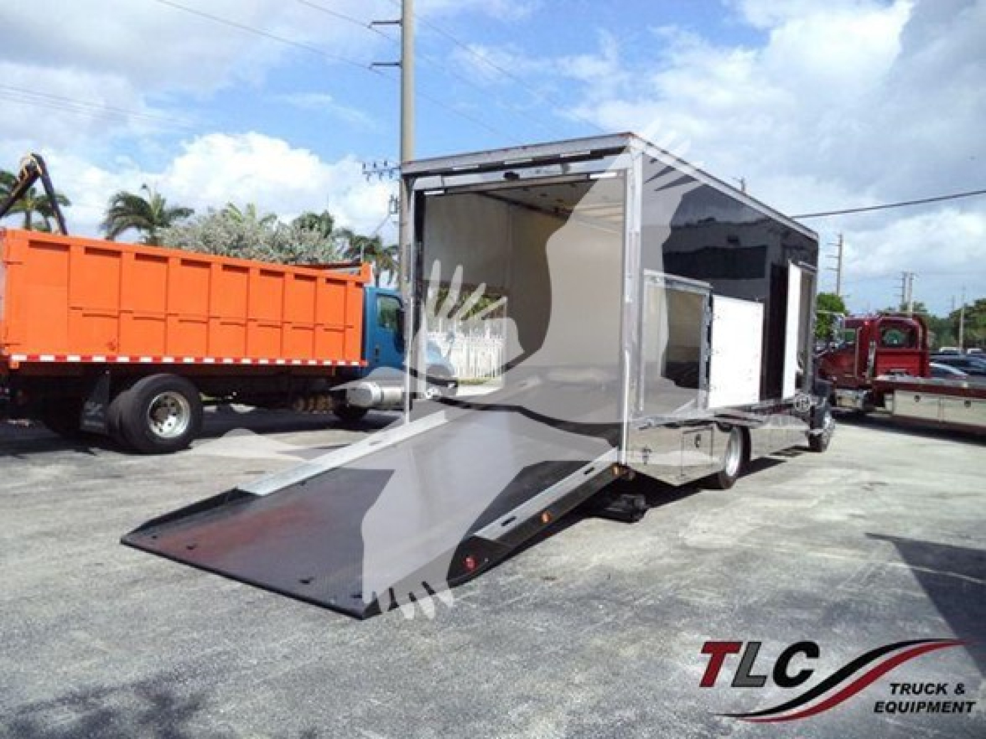 Mack MD6 rollback truck trailer with ramp extendable at rear and side access door showing interior. Teal/gray color with open cargo area.