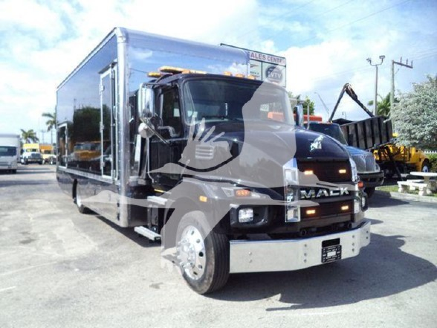 MD6 Mack rollback truck with reflective wrap showing Mack branding on grille and side, oil and coolant labels not clearly readable.