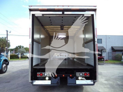 Truck rear view showing empty enclosed cargo area in a 2022 Mack MD6 rollback truck with open rear doors and reflective taillights.