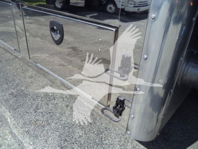 Aluminum tool/utility truck body side compartment with latch and door; reflection of vehicles in background.