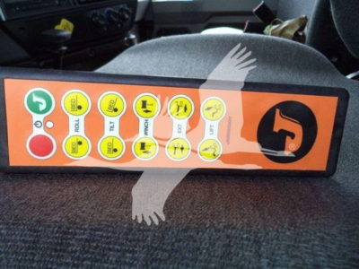 Dashboard control panel with multiple circular icons and green start/green indicators, orange background. Brand logo on right. Text on circles includes labels like ROLL, TILT, etc.