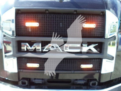 Mack MD6 grille front view showing illuminated amber clearance lights and MAC K emblem.