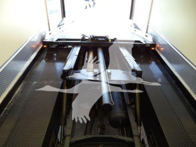 View inside Mack MD6 rollback truck bed showing hydraulic components and chassis frame with platform; no identifiable text visible.