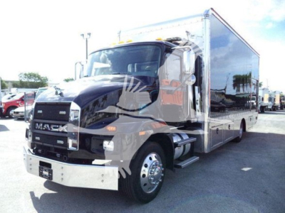 Mack MD6 truck in service, side view showing cab and large cargo box, front grille with Mack emblem, headlights, chrome bumper.