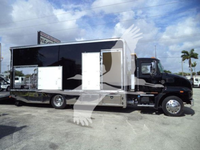 2022 Mack MD6 roll-back truck side view showing large black and silver cargo body with white access panels and chrome wheels.