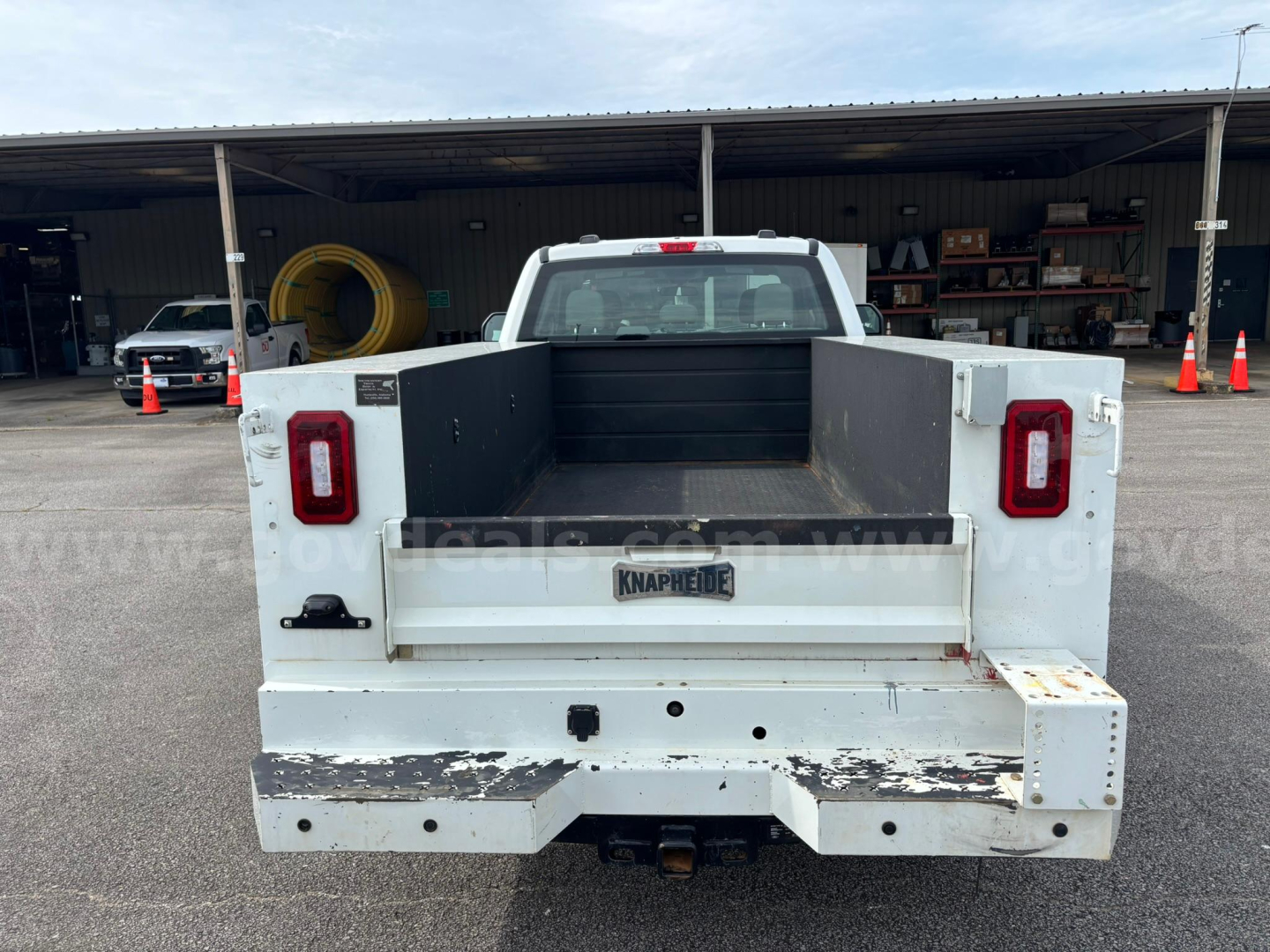 Ford F-250 utility truck bed showing farm-style flatbed with white paint and rear tailgate