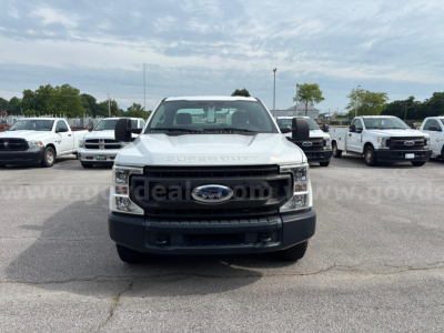 Ford F-250 frontal view showing grille emblem and headlights in a dealership lot.