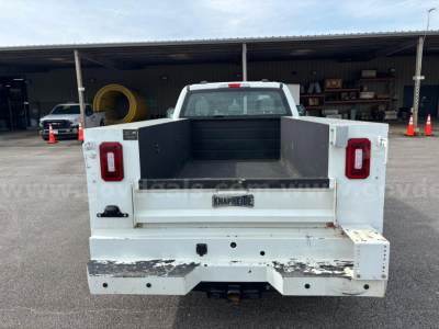 Ford F-250 utility truck bed showing farm-style flatbed with white paint and rear tailgate