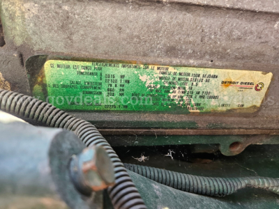 Label plate on Freightliner cab and chassis showing engine specs and identifiers; green/yellow sticker with text and numbers.