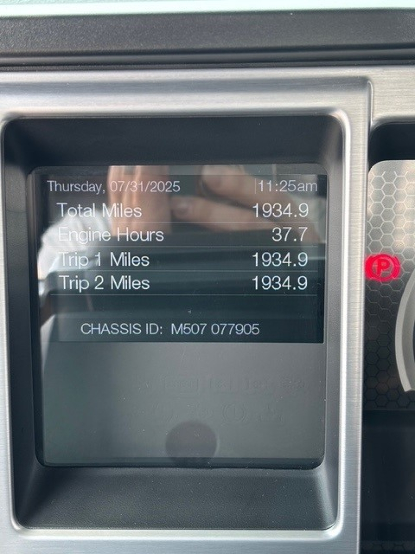 MD7 dash display showing total miles 1934.9, engine hours 37.7, trip 1 miles 1934.9, trip 2 miles 1934.9, chassis ID M507 077905 on Mack truck dashboard display.