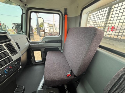 Cab interior of a 2026 Mack MD7 truck showing driver seat and dashboard with control panel and window.