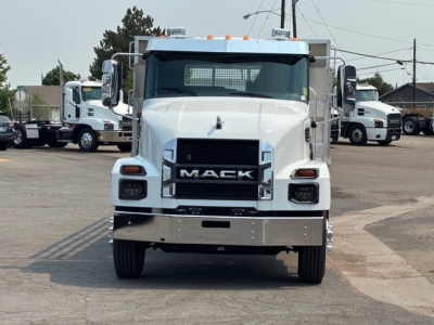 Front view of a white Mack MD7 flatbed truck showing Mack grille, headlights, chrome bumper, and stock number area.
