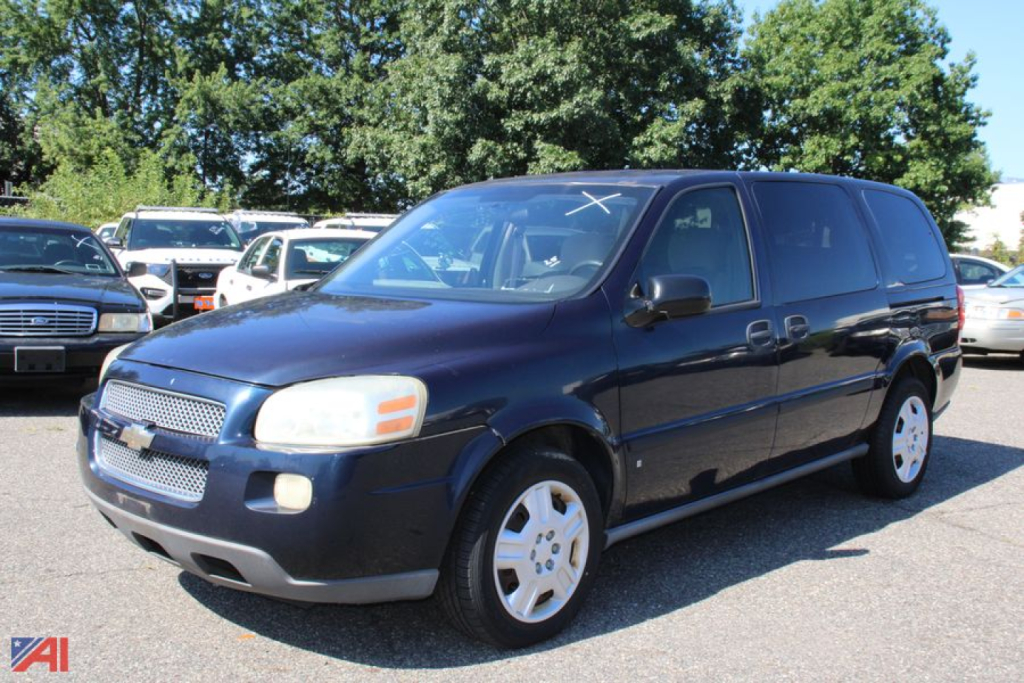 Chevrolet Uplander minivan in blue, front three-quarter view, with logo, headlights, and alloy wheels visible in a used car lot.