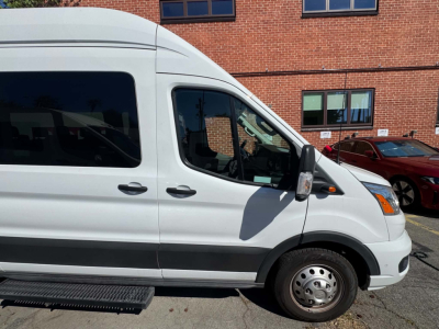 Ford Transit 350 HD van side view showing front door, wheel, and step in pristine exterior.