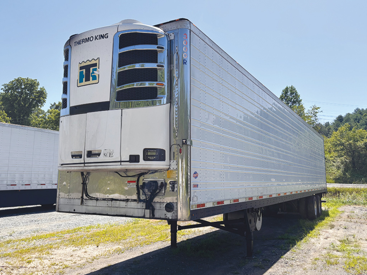 Thermo King unit on front of a 2014 Utility 3000R refrigerated trailer with silver corrugated sides and dual rear wheels.