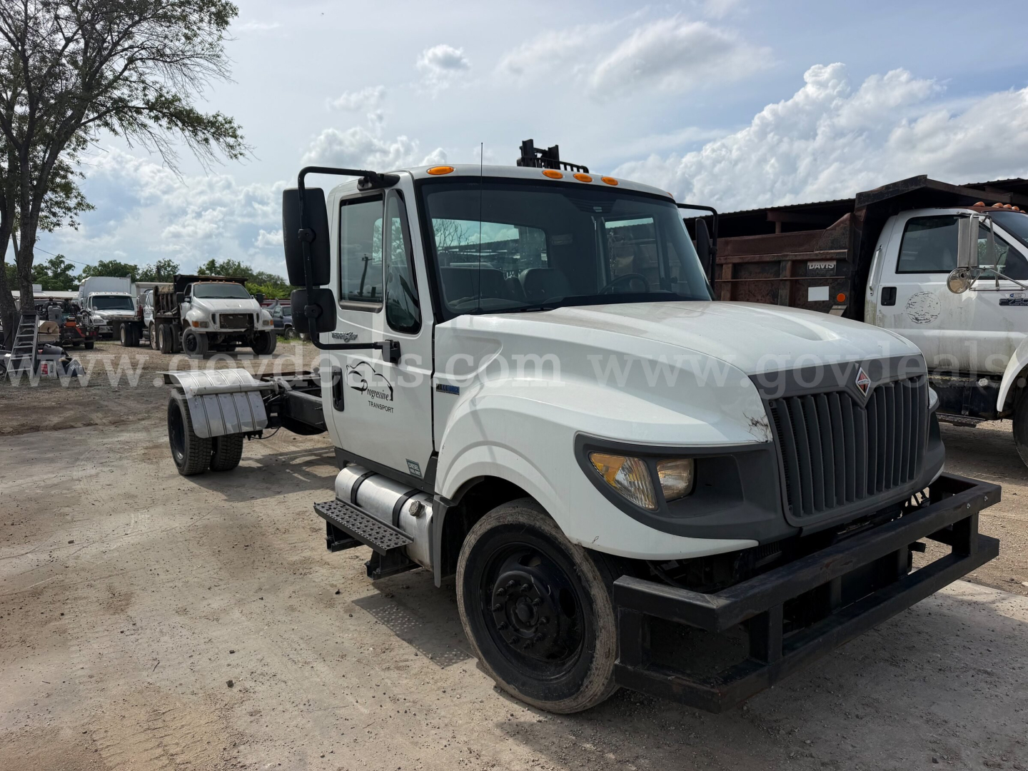 Truck cab and chassis of a white 2014 International TerraStar SFA 4x2 dual rear wheel cab and front bumper with black grille and warning lights.
