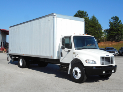 Freightliner M2 106 box truck with white cab and cargo box, side view showing front grille and wheel tires.