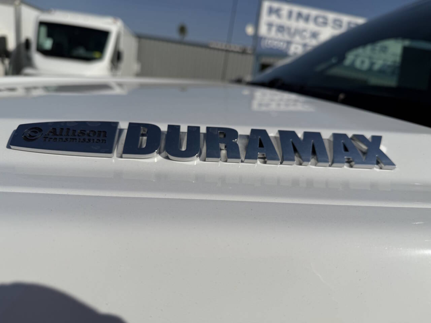Duramax badge on Chevrolet truck hood showing Allison transmission badge and chrome lettering.