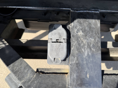 Chevrolet 6500 HD chipper truck front section showing electrical/warning plug cover and metal hitch area.