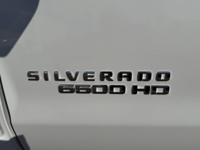 Chevrolet Silverado 6500 HD badge on white truck side panel showing 'SILVERADO 6500 HD' text.