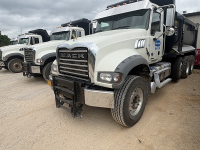 Mack GR84F dump truck showing front grille with Mack emblem and bumper; white cab with black bumper guard and dual rear wheels.