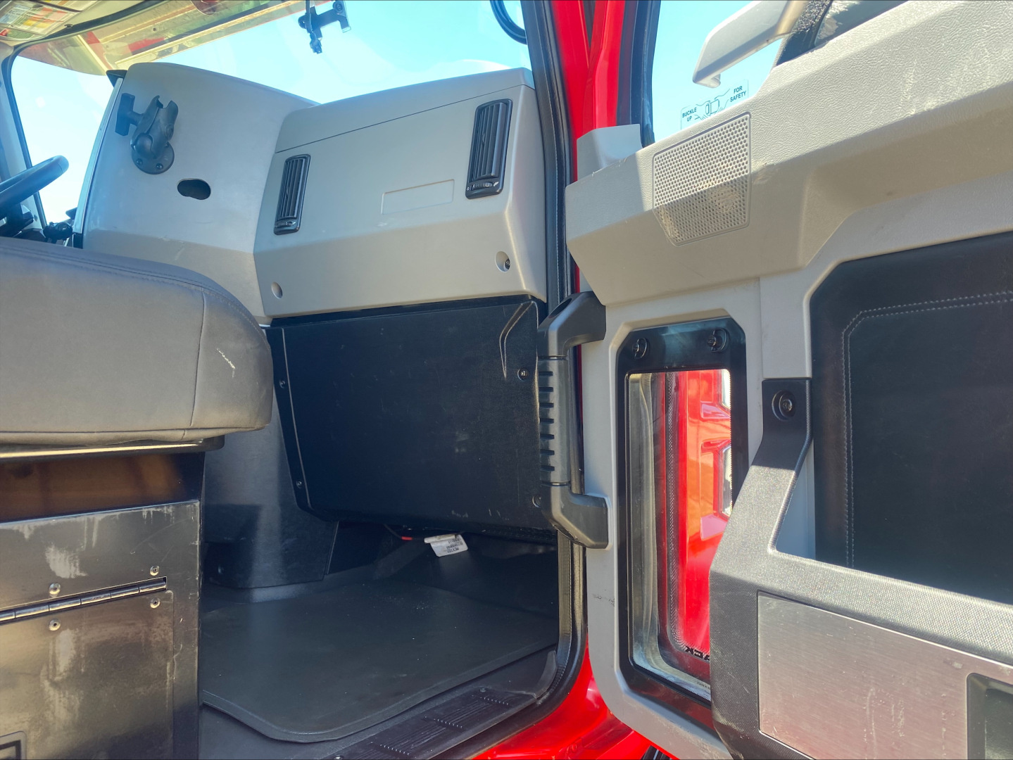 Cab interior of 2021 Mack AN64T truck showing dash panels and open doorway with cargo area edge.