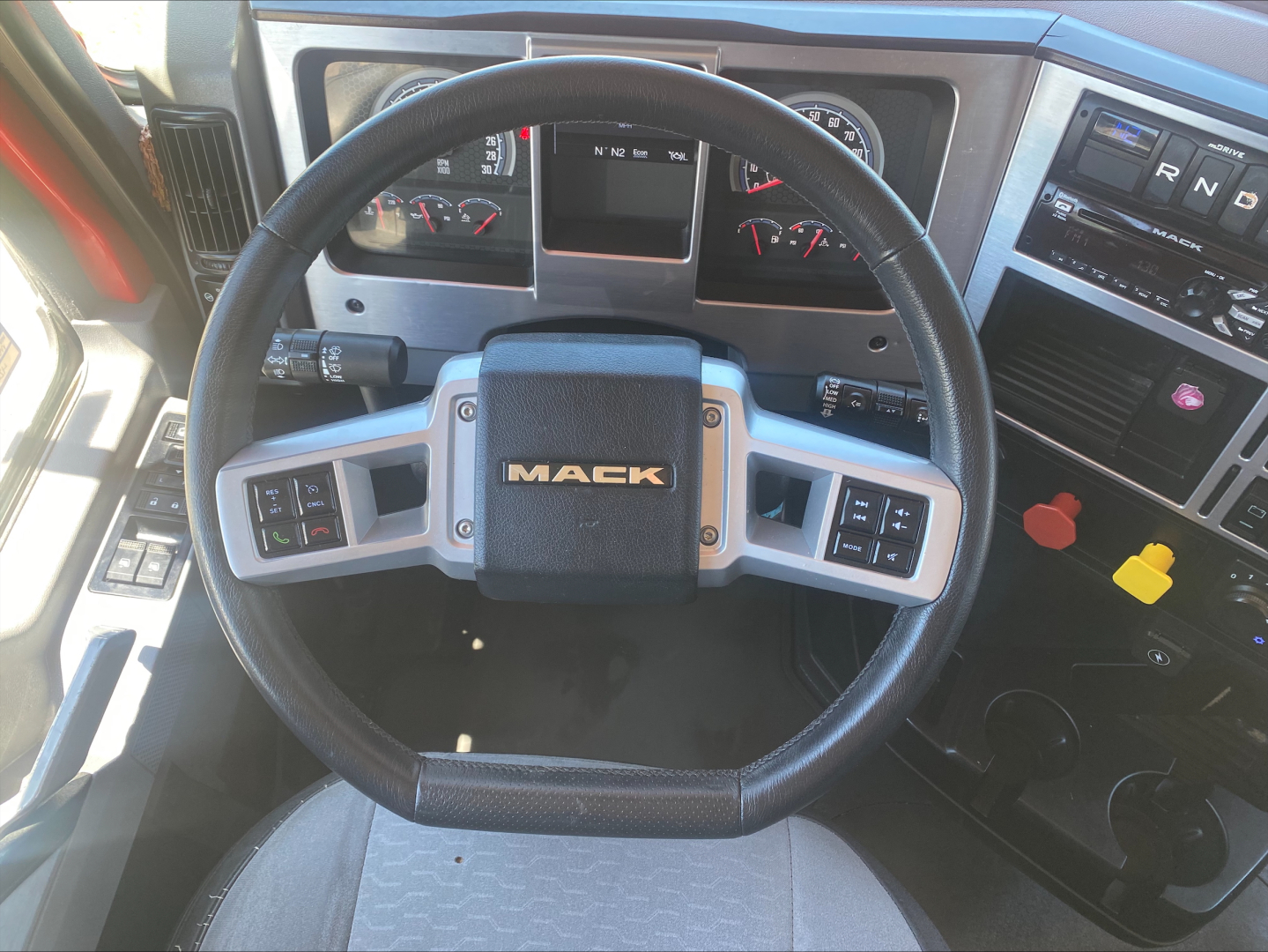 Mack AN64T dashboard and steering wheel showing Mack logo on center and instrument cluster.