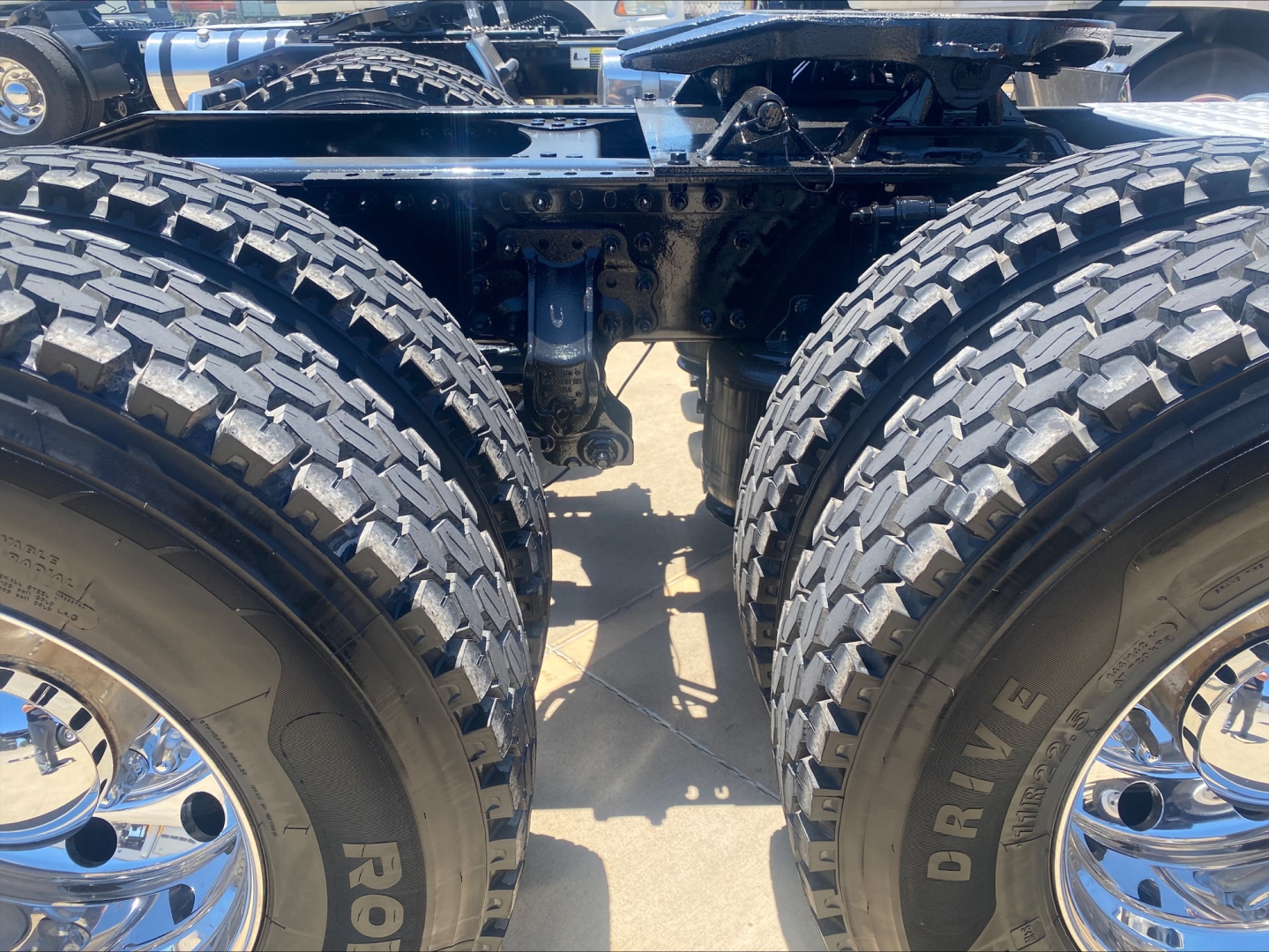 Mack AN64T chassis with dual rear axles and large off-road tires showing suspension and frame.