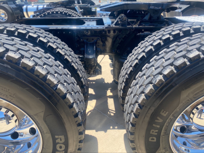 Mack AN64T chassis with dual rear axles and large off-road tires showing suspension and frame.