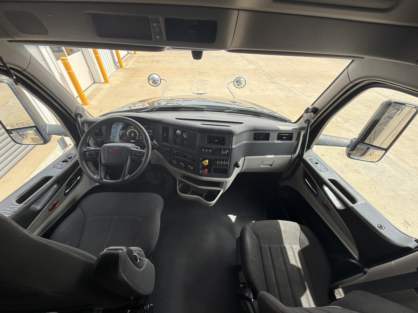 Truck cabin interior of a 2022 Peterbilt 579 with steering wheel, dashboard, and driver seat visible.