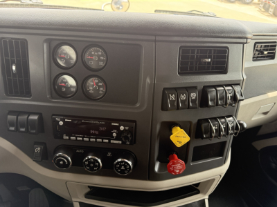 Peterbilt 579 dash and control panel showing gauges, switches, and yellow/red handles in the cab interior.