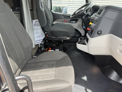 Peterbilt 579 truck interior showing driver's seat, front passenger seat, steering wheel, dashboard, and center console.