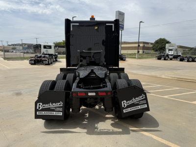 Rear view of a 2022 Peterbilt 579 truck tractor with fifth wheel, dual rear axles, and mud flaps displaying Bruckner's Used Trucks Oklahoma City branding.