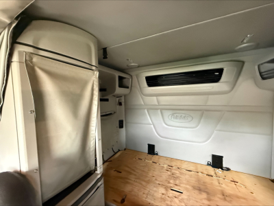 Peterbilt 579 sleeper cab interior with cargo area, side wall storage, and window vent visible.