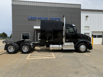 Peterbilt 579 truck cab and chassis in front of a used truck center building.